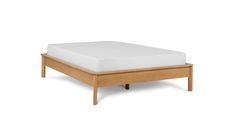 the bed frame is made from solid wood and has white sheets on top of it