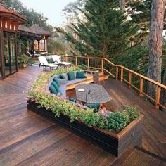 an outdoor deck with seating and trees in the background