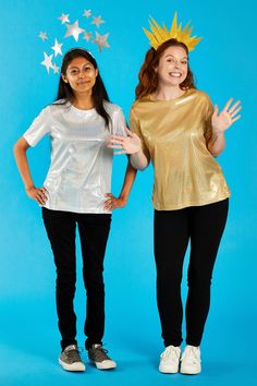 two young women in gold and silver outfits posing for the camera with their hands up