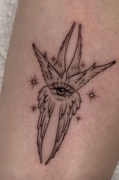 a small tattoo on the leg of a woman with an owl's eye and stars