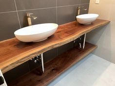 two white bowls are sitting on a wooden shelf