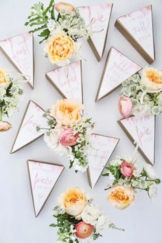 flowers are arranged on top of triangular wooden signs