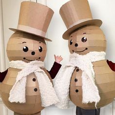 two paper mache snowmen standing next to each other