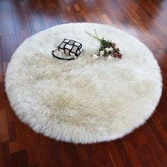 a white round rug with flowers and a black object on the floor next to it