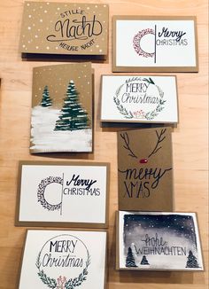 six christmas cards on a wooden table