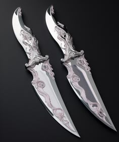 two knives with intricate designs on them sitting next to each other in front of a black background