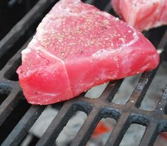 two pieces of meat cooking on top of a grill