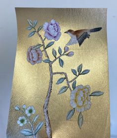 a gold plate with flowers and a bird on it