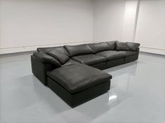 a black leather sectional sofa in an empty room