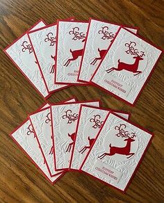 six christmas cards with reindeers on them sitting on a wooden table next to each other