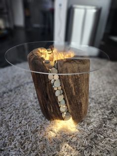 a glass table with rocks on it and a fire in the middle, sitting on carpeted area