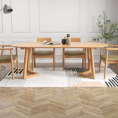 a wooden table with chairs around it on a rug in front of a white wall