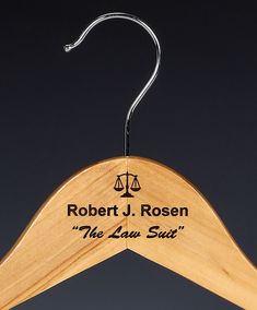 a wooden suit hanger with the name robert j rosen on it and an equal scale