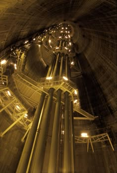 a very tall tower with lots of lights on it's sides in the middle of a tunnel