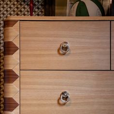 a wooden dresser with two drawers and knobs