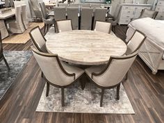 a dining room table surrounded by chairs and rugs in front of a store display