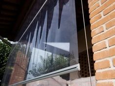 an open window on the side of a brick building with icicles hanging from it