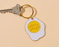 an egg shaped keychain with the words totally fried on it's side