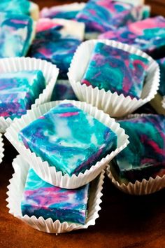 blue and pink swirled desserts sitting on top of a wooden table