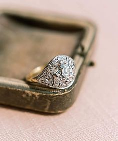 an antique diamond ring sits in a case