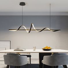 a dining room table with chairs and a bowl of fruit on it