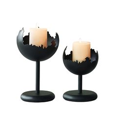 two lit candles sitting on top of each other