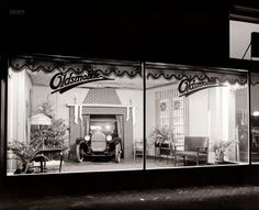 an old fashion store front at night with its windows lit up and the lights on