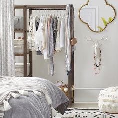 a bedroom with clothes hanging on the rack