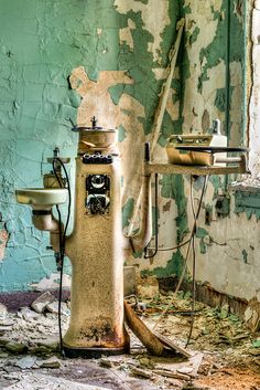 an old rusted bathroom with a broken toilet and sink