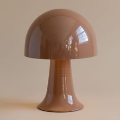 a brown lamp sitting on top of a table next to a white wall and floor