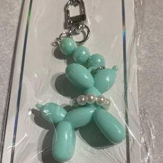 a keychain shaped like a dog with pearls on it