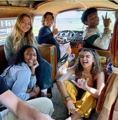 a group of people sitting in the back of a car with their hands up and smiling