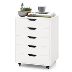 a white dresser with four drawers and a potted plant sitting on top of it