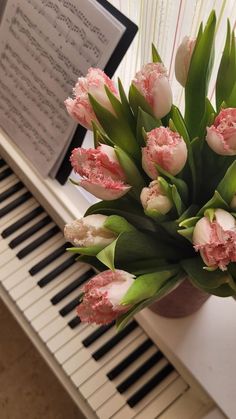 a bouquet of tulips sitting on top of a piano