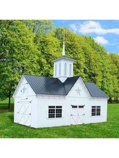 a small white building with a steeple on top in the middle of a field