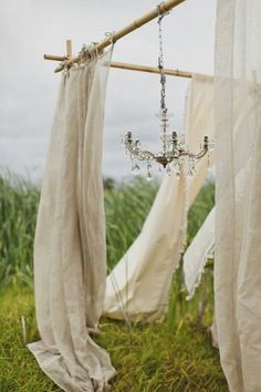 a chandelier hanging from a wooden pole in the grass