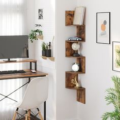 a desk with a computer on top of it next to a potted plant and window