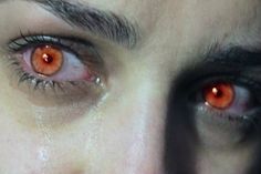 an orange eye is reflected in the reflection of a woman's face and eyes