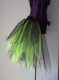 a green and black dress on a mannequin headdress with purple trim