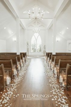 the aisle is decorated with white flowers and candles