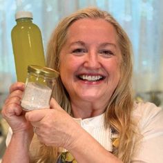 a smiling woman holding a jar and a bottle