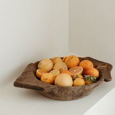 a wooden bowl filled with different types of fruit