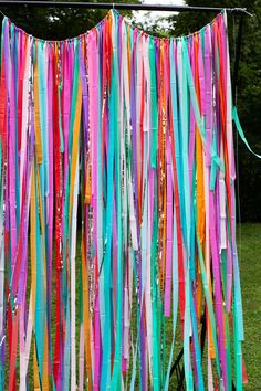 colorful streamers hanging from a line in the grass