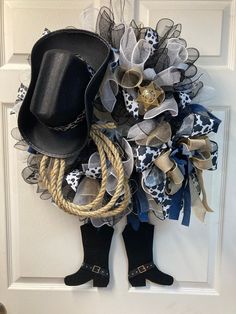 a cowboy hat and boots wreath hanging on a door