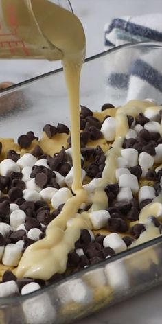 someone is pouring marshmallows and chocolate into a casserole dish for dessert