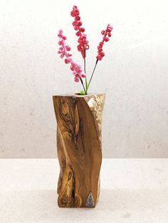 a wooden vase with pink flowers in it