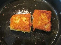 two square pieces of food cooking in a frying pan