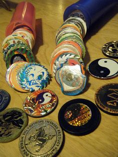 many different colored and shaped badges on a wooden table next to a blue blow dryer