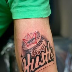 a man with a tattoo on his arm has a crown and the word hustle