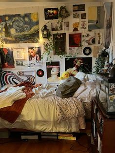 a bed room with a neatly made bed and lots of pictures on the wall